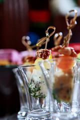 Cheese canapes with walnuts in a glass glass. Catering services for events. Photo on a dark background. Copy of the space