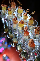 Fototapeta na wymiar heese canapes with grapes and walnuts on the festive table. Catering services for events. Photo on a dark background.