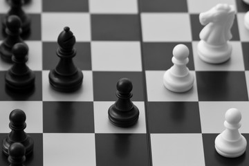 Black and white chessmen on chessboard
