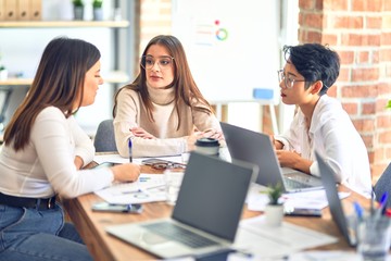 Beautiful businesswomen smiling happy. Sitting with smile on face working using laptop at the office