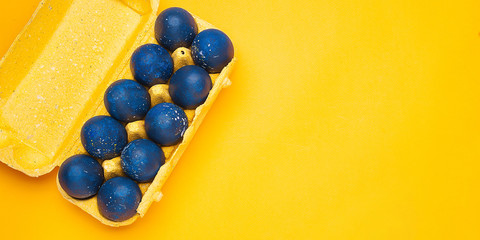 Blue eggs on a yellow background. trendy Easter egg of color of the year-classic blue, Top view
