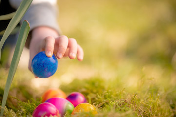 Kinderhand greift nach Ostereier in einem Nest