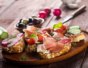 Set of different bruschettas on dark wooden table.