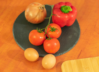 close-up chopped tomato onion bell pepper on dark slate