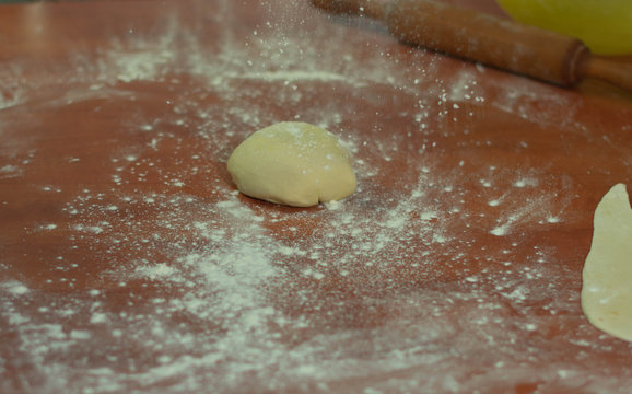 ball of dough on the table to flatten with the rolling pin and make a base of dough
