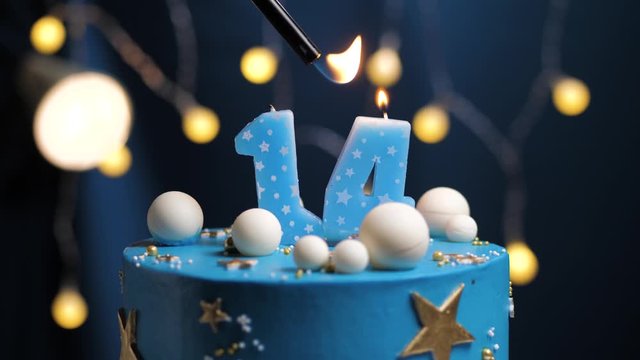 Birthday cake number 14 stars sky and moon concept, blue candle is fire by lighter and then blows out. Copy space on right side of screen if required. Close-up and slow motion