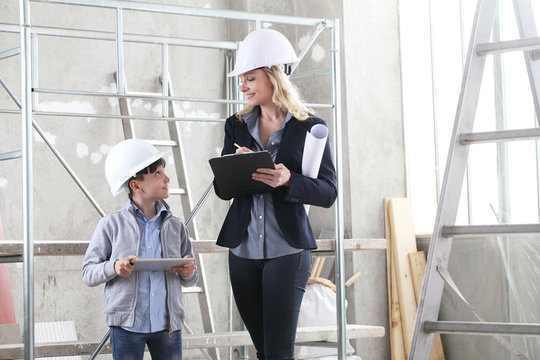 woman interior designer or architect mom with her son they work together on the construction of the house, inside the building site