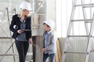 woman interior designer or architect mom with her son at work, they choose how to furnish the...