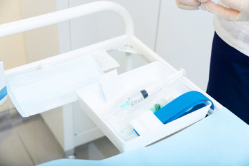 syringe with medicine on the treatment table and tourniquet for intravenous injection. On the table are medical items and injection syringes. introduction of contrast for MRI