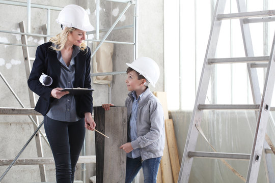 woman interior designer or architect mom with her son at work, they choose how to furnish the house, inside the construction site