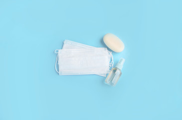 Blue face mask with soap and hand antiseptic on a light background. Protection from the virus.