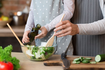Daddy and little daughter cooking veggie salad together in kitchen