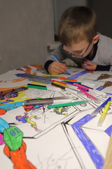 boy paints with markers coloring, crooked posture, classes in quarantine for children