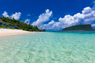 Tropical beach on south side of Samoa Island with coconut palm trees