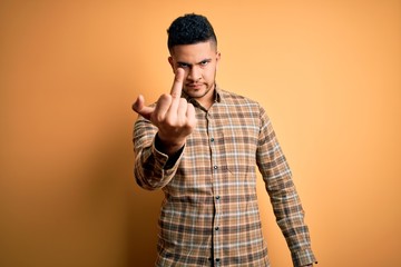 Young handsome man wearing casual shirt standing over isolated yellow background Showing middle...