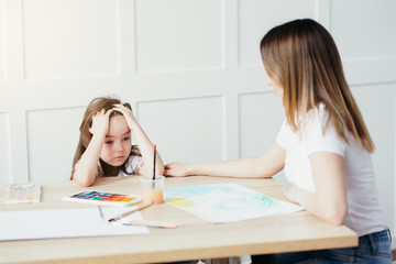 Fototapeta premium Daughter upset that she can't draw as beautiful as your mom. Art therapy for young children