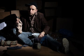 The homeless man managed to get food and begins to eat it.