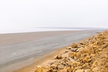 Tuz salt lake dull  panorama with misty and rocky landscape. View from the road.
