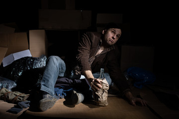A middle-aged homeless man puts on woolen gloves.