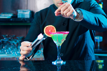 Preparando Cocktail: Barman colocando rodaja de limon sobre copa de cocktail / Preparing Cocktail: Barman placing lemon wedge on cocktail glass