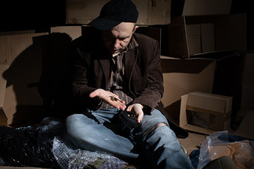 A homeless middle-aged man counts the money collected.