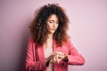 Young beautiful businesswoman with curly hair and piercing wearing elegant jacket Checking the time...