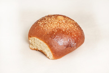 Fresh bread loaf sprinkled with grated walnut. Closeup on a light background
