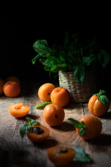 Fototapeta na wymiar Apricots with mint in dark key 