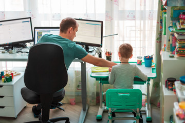 Father with kid working from home during quarantine. Stay at home, work from home concept during...