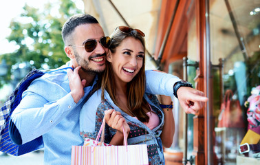 Attractive young couple enjoying in shopping. Consumerism, love, dating, lifestyle concept