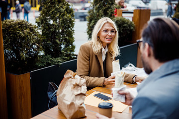 Cheerful blonde woman looking at her coworker