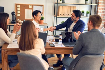 Group of business workers smiling happy and confident. Working together with smile on face shaking hands at the office