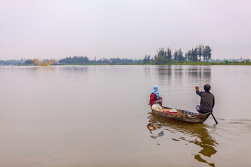 Fototapeta na wymiar Fishing by Sampan at dawn on the Thu Bon river, Hoi An, Vietnam