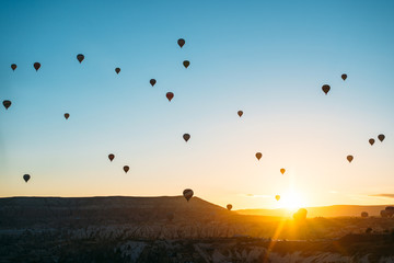 sunrise with hot air baloons in the air