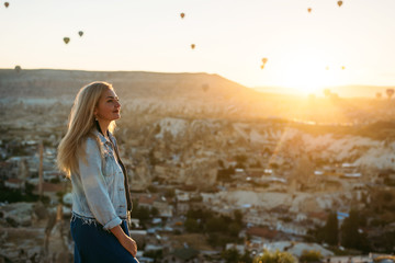 Young woman watching the sunrise in Cappadocia