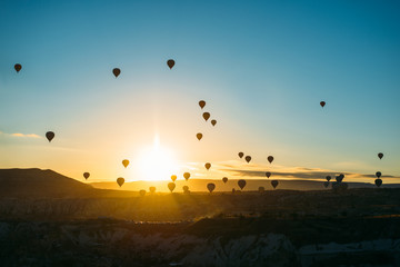 sunrise with hot air baloons in the air