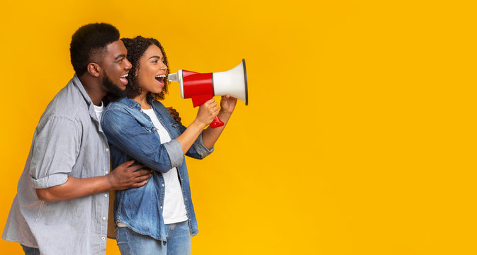Joyful African American Couple Making Announcement Using Loudspeaker, Panorama