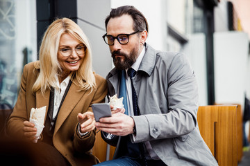 Man showing photos to her female colleague