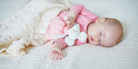 Baby girl having a nap with mouse toy