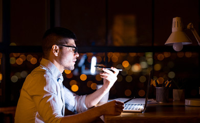 Serious Entrepreneur Using Loudspeaker Talking On Cellphone In Modern Office