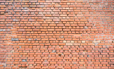 Red brick wall partially destroyed by rain. Texture.