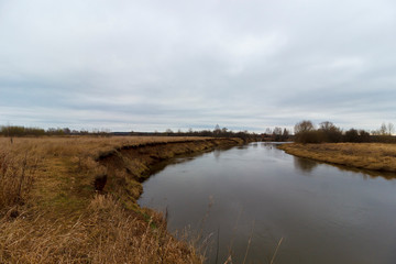 
River with rippling banks and yellowed grass