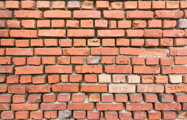 Red brick wall partially destroyed by rain. Texture.