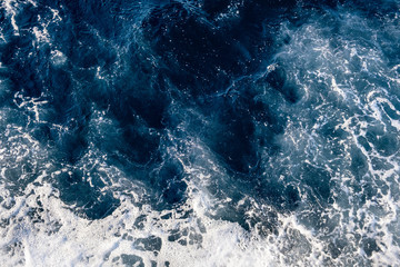 Top down aerial view of sea water surface. White foam waves texture as natural background.