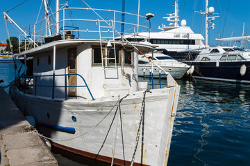 Fishing boat moored at the dock. A typical old fishing boat anchored in the harbor along with...