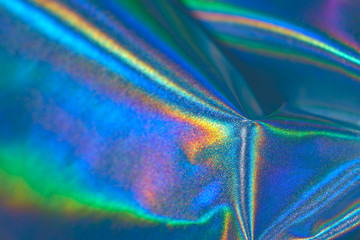 iridescent holographic fabric background blurred in blue shades of rainbow colors