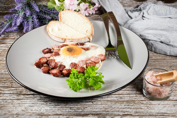 Fried egg with chopped sausage.