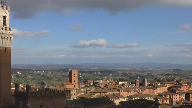 Italy. View from Panorama dal Facciatone on the beautiful rooftops of Siena and the Torre del Mangia (literally - Tower of the Devourer)
