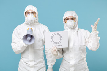 People in protective suits respirator masks scream in megaphone isolated on blue background studio. Epidemic pandemic new rapidly spreading coronavirus 2019-ncov medicine flu virus concept