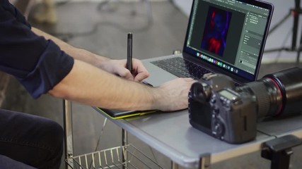 Hands of a male photographer, designer use a graphics tablet. Close up, slider shot. - Powered by Adobe
